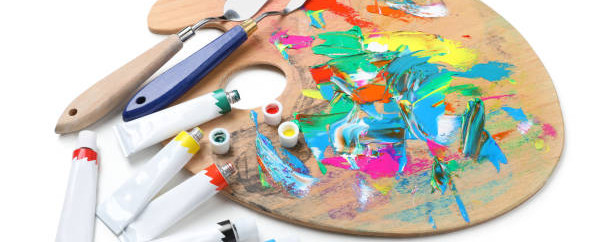 Palette with acrylic paints and spatulas on white background. Artist equipment